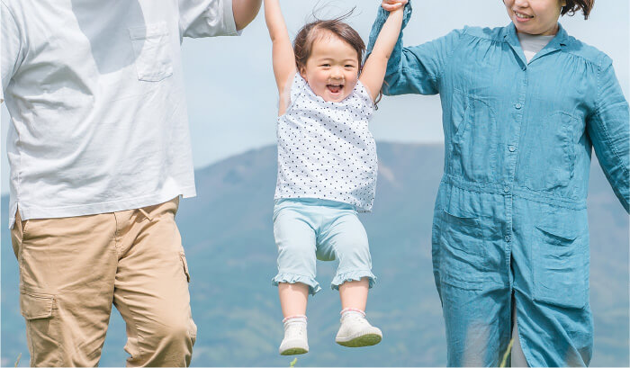 両親に持ち上げられる子供